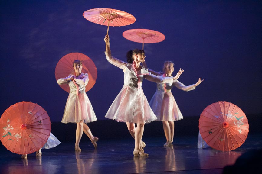 Need descriptions for each of the images       Intermediate Ballet Technique class          dancer flying off back of another dancer          duet using chair as a prop          confetti in air, dancers showing exuberance          dancers in Chinese folk fan dance          dancers making a group shape that is reaching for light          dancers holding umbrellas upward, with delight          duet dancing with sofa          duet in soft blue light, making a pose          dancers on stage in blue light in a lunge          dancers in circle surrounding a soloist          duet dancing in soft blue light in a curved shaped pose          duet in a lift